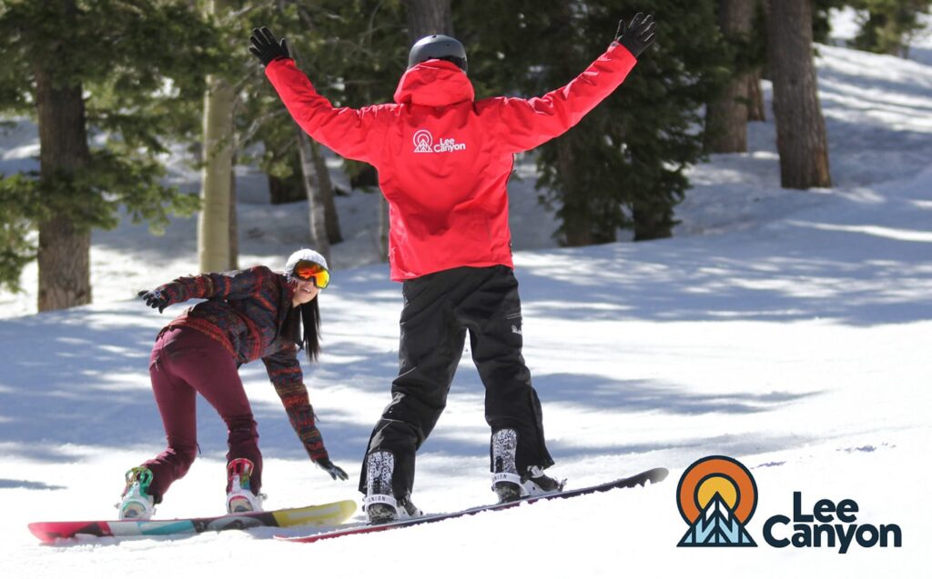 Snowboarder learning how to snowboard with an instructor at Lee Canyon Resort